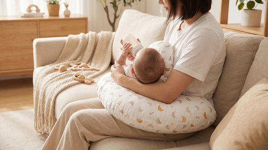 Ouder geeft de fles met de baby op het witte voedingskussen van Laavir