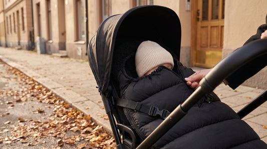 Zwarte winddichte voetenzak van Laavir in een buggy op een herfstige wandeling